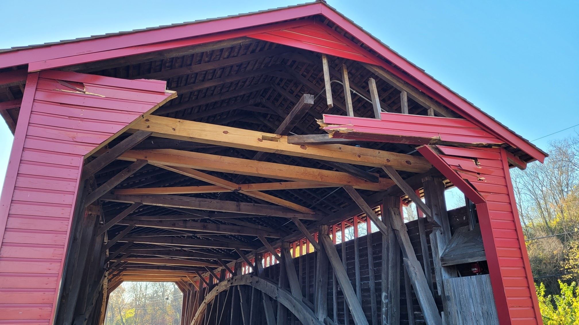 A covered bridge with damage to the structure