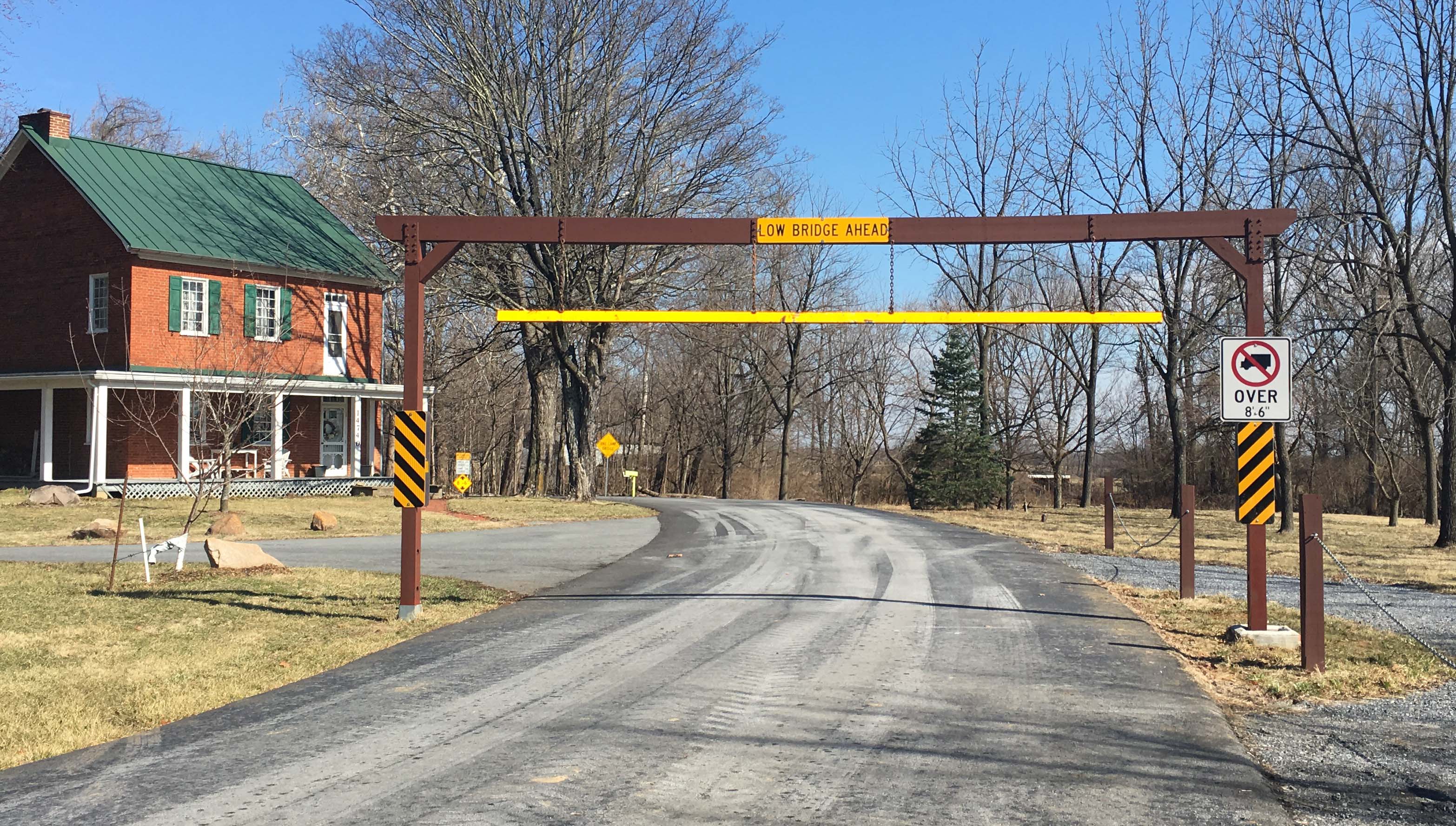 A metal structure alerts tall vehicles if they can fit inside a covered bridge.
