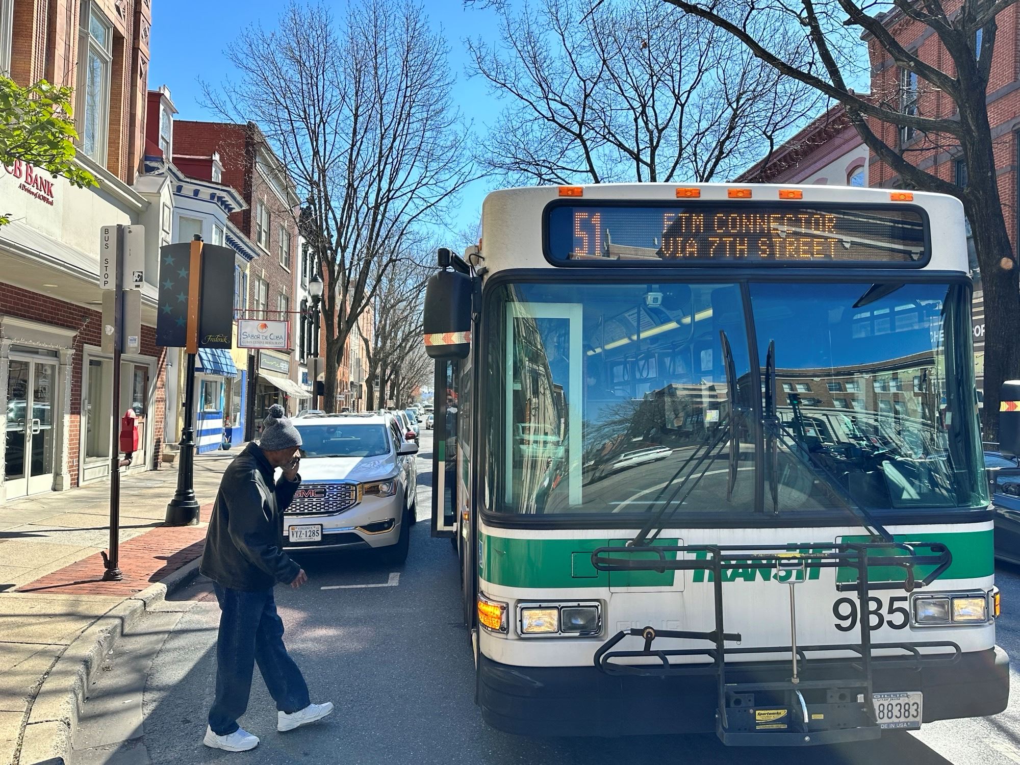 A person boards a bus on a downtown street