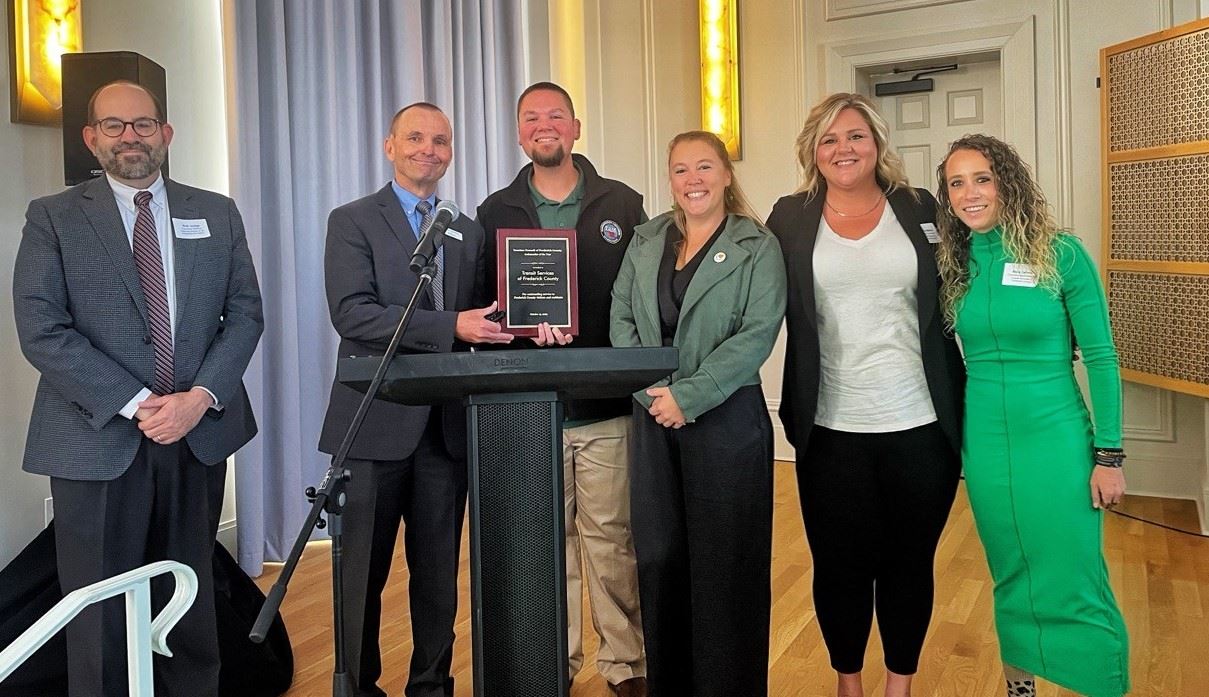 A group of people posing with an award.