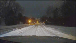 A snowy road at night.